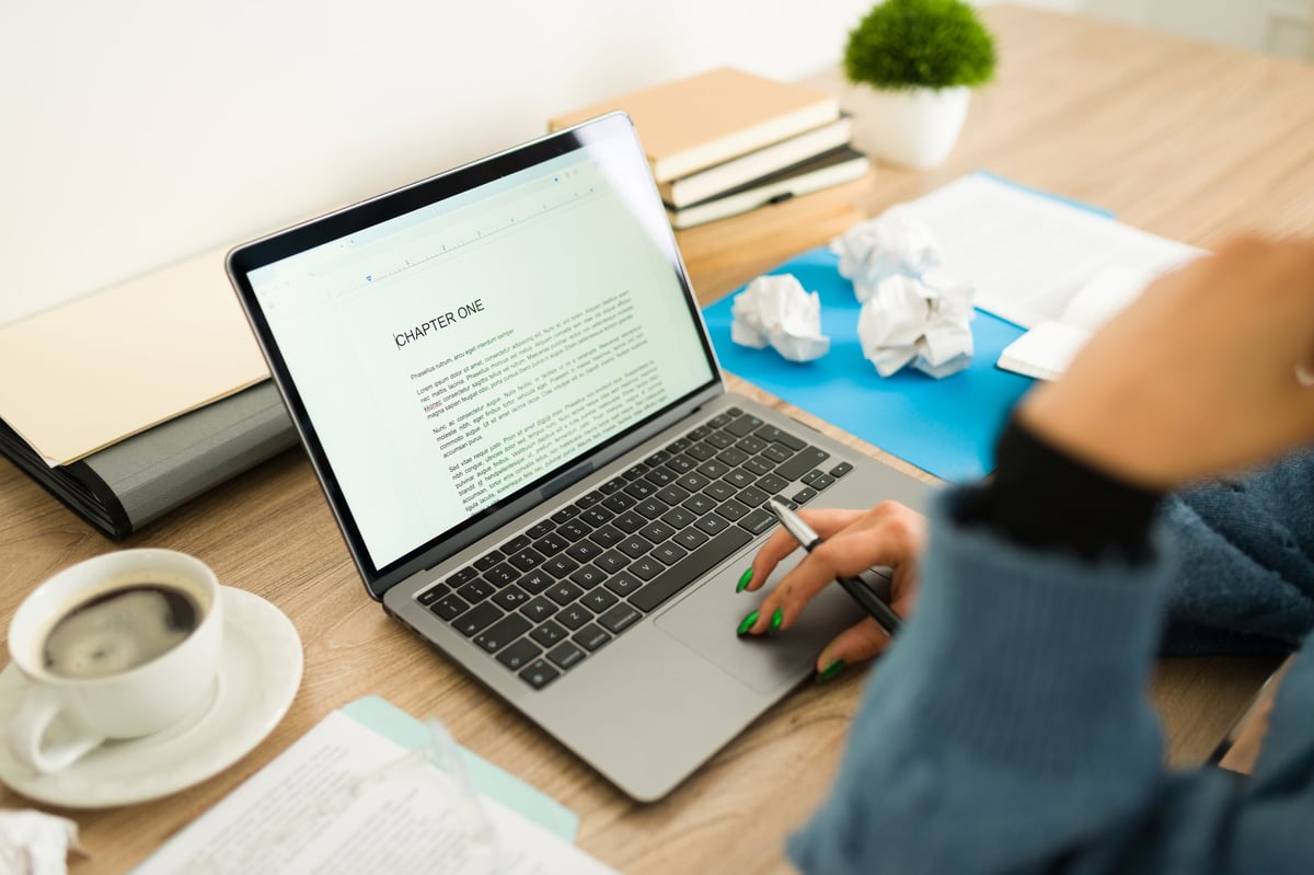 Author writing her new book with laptop and coffee