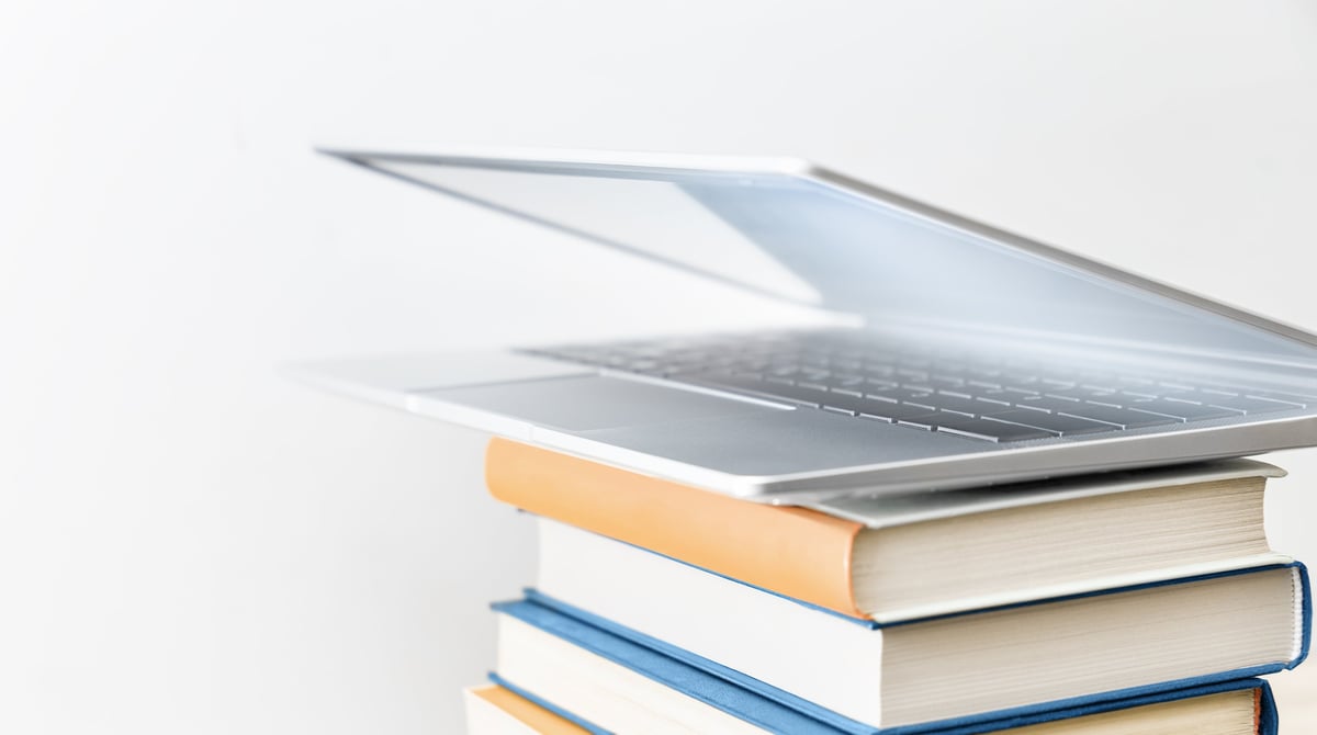 Laptop open on stack of books